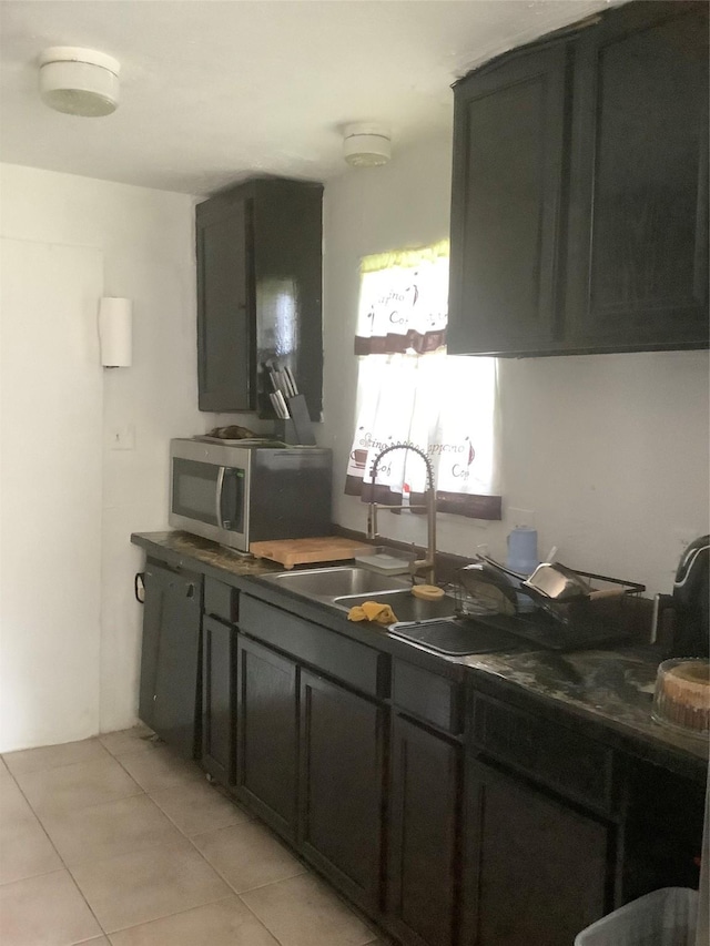 9406 Jolly Wood Ct, Houston, TX 77086 - kitchen with stainless steel microwave, light tile patterned flooring, dishwashing machine, and dark countertops