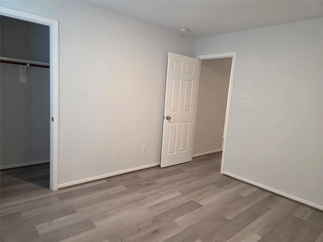 2703 Oakland Brook St, Houston, TX 77038 - unfurnished bedroom with wood finished floors, a walk in closet, and a closet