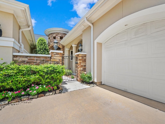 6922 Carolina Cherry Ln, Spring, TX 77389 - view of exterior entry featuring stucco siding, a gate, stone siding, and concrete driveway