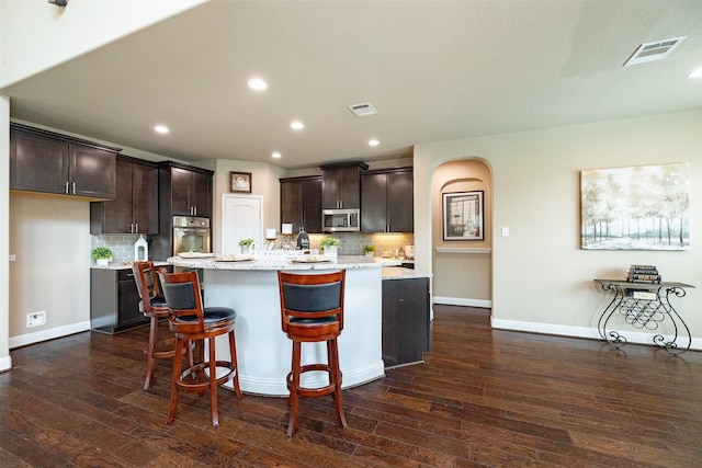 27619 Dalton Bluff Ct, Katy, TX 77494 - kitchen featuring appliances with stainless steel finishes, dark wood-type flooring, dark brown cabinets, tasteful backsplash, and recessed lighting