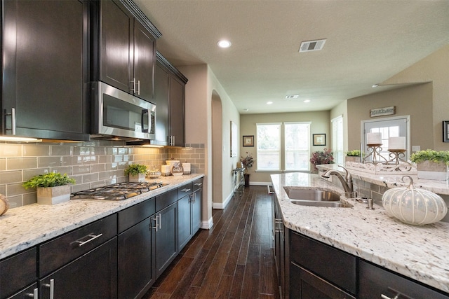 27619 Dalton Bluff Ct, Katy, TX 77494 - kitchen featuring appliances with stainless steel finishes, dark wood-style floors, light stone counters, backsplash, and recessed lighting