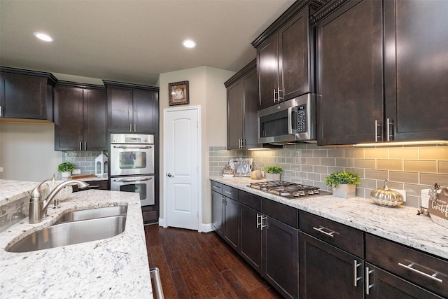 27619 Dalton Bluff Ct, Katy, TX 77494 - kitchen featuring stainless steel appliances, light stone countertops, dark wood-type flooring, dark brown cabinetry, and recessed lighting