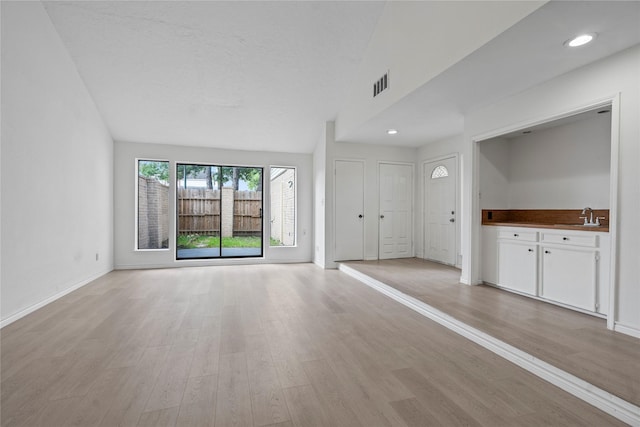 11011 Bandlon Dr, Houston, TX 77072 - unfurnished living room with light wood-style floors, recessed lighting, and vaulted ceiling