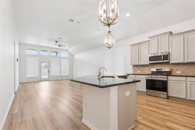 9427 Harmony Lake Ln, Richmond, TX 77469 - kitchen featuring appliances with stainless steel finishes, a chandelier, lofted ceiling, dark countertops, and backsplash