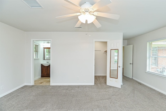 4502 Sanford Rd, Houston, TX 77035 - unfurnished bedroom with a walk in closet, light carpet, connected bathroom, a closet, and a ceiling fan