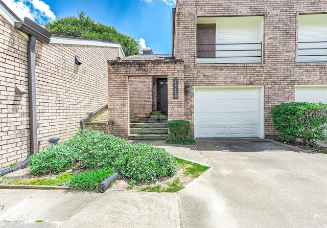 16160 Seahorse Dr, Houston, TX 77062 - doorway to property featuring concrete driveway, an attached garage, and brick siding