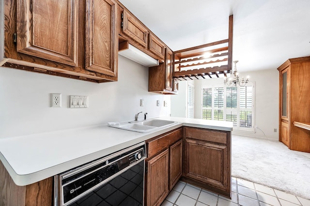 16160 Seahorse Dr, Houston, TX 77062 - kitchen with black dishwasher, light colored carpet, a chandelier, light countertops, and a peninsula