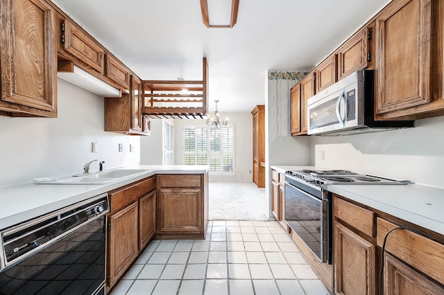 16160 Seahorse Dr, Houston, TX 77062 - kitchen featuring stainless steel appliances, brown cabinetry, light countertops, and light colored carpet