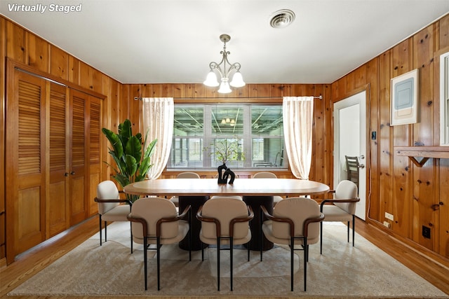 3014 Castlewood St, Houston, TX 77025 - dining room with wood walls, a chandelier, and light wood finished floors