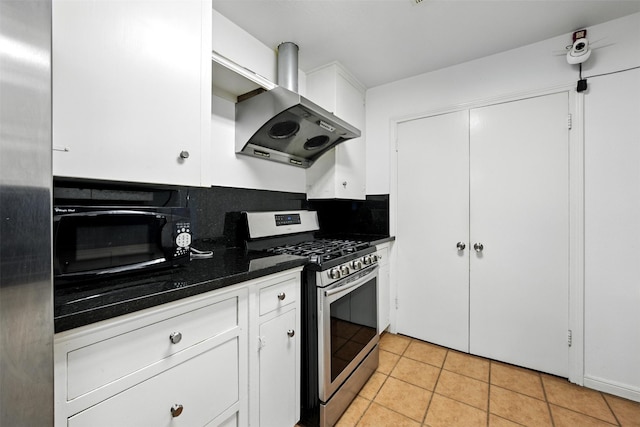 3014 Castlewood St, Houston, TX 77025 - kitchen featuring wall chimney exhaust hood, gas range, black microwave, dark countertops, and white cabinetry