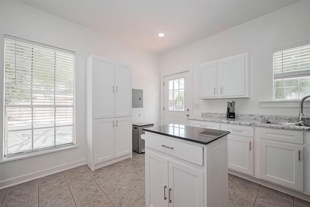 4401 Canal St, Houston, TX 77011 - kitchen featuring white cabinets, a center island, light tile patterned floors, recessed lighting, and light stone countertops