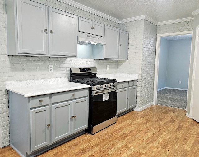 7715 Lobera Dr, Houston, TX 77083 - kitchen with gray cabinets, stainless steel gas range oven, under cabinet range hood, ornamental molding, and light wood finished floors