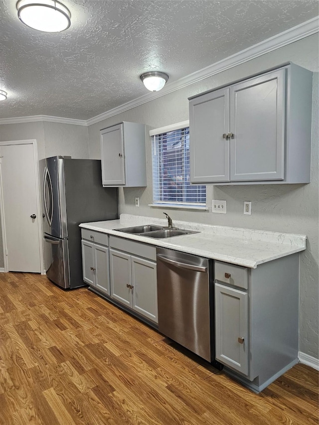 7715 Lobera Dr, Houston, TX 77083 - kitchen featuring stainless steel appliances, gray cabinets, wood finished floors, a textured ceiling, and crown molding