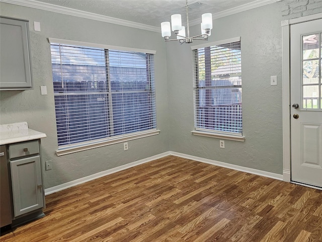 7715 Lobera Dr, Houston, TX 77083 - unfurnished dining area with wood finished floors, a chandelier, a textured wall, and ornamental molding
