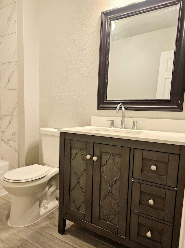 7715 Lobera Dr, Houston, TX 77083 - full bathroom with vanity, wood finished floors, a bathtub, and a textured wall
