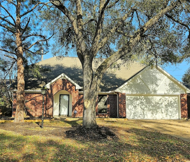 7715 Lobera Dr, Houston, TX 77083 - view of front facade featuring brick siding, an attached garage, concrete driveway, and roof with shingles