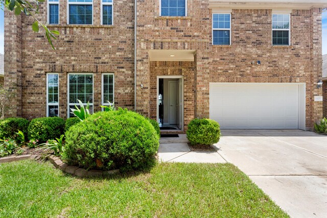 6605 Fallen Breeze Ln, Dickinson, TX 77539 - view of front of house with a garage, concrete driveway, and brick siding