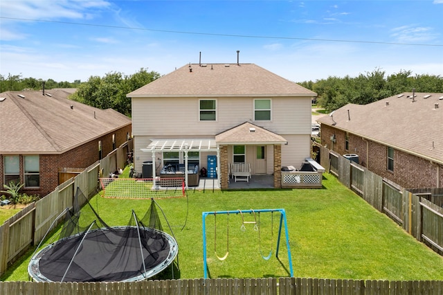 6605 Fallen Breeze Ln, Dickinson, TX 77539 - rear view of house with a trampoline, a patio, a fenced backyard, a shingled roof, and a playground