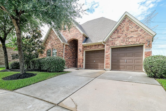 9335 Mystic Falls Ln, Humble, TX 77396 - traditional-style home featuring concrete driveway, a garage, brick siding, and a shingled roof