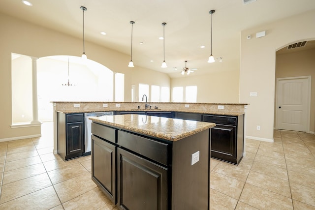 9335 Mystic Falls Ln, Humble, TX 77396 - kitchen with a center island, light tile patterned floors, arched walkways, stainless steel dishwasher, and ceiling fan