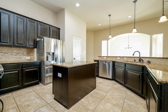 9335 Mystic Falls Ln, Humble, TX 77396 - kitchen with appliances with stainless steel finishes, a center island, tasteful backsplash, light tile patterned flooring, and recessed lighting