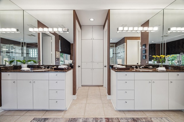 2409 Maconda Ln, Houston, TX 77027 - bathroom featuring a shower stall, two vanities, and tile patterned floors
