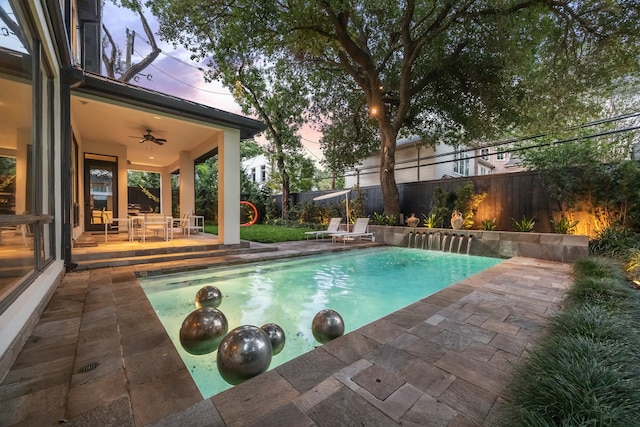 2409 Maconda Ln, Houston, TX 77027 - pool at dusk with ceiling fan, a fenced backyard, and a patio area