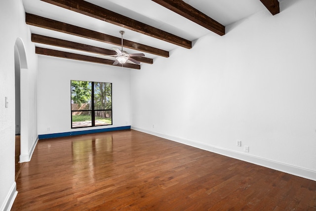 15810 Juneau Ln, Jersey Village, TX 77040 - spare room with arched walkways, a ceiling fan, wood finished floors, and beamed ceiling