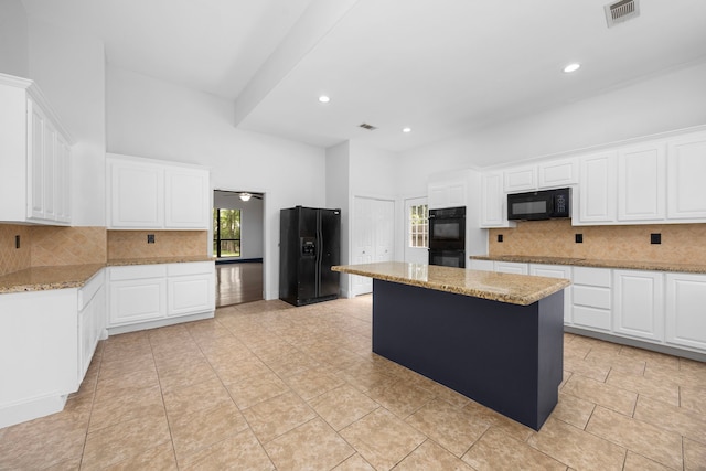 15810 Juneau Ln, Jersey Village, TX 77040 - kitchen featuring black appliances, backsplash, light stone counters, recessed lighting, and a towering ceiling