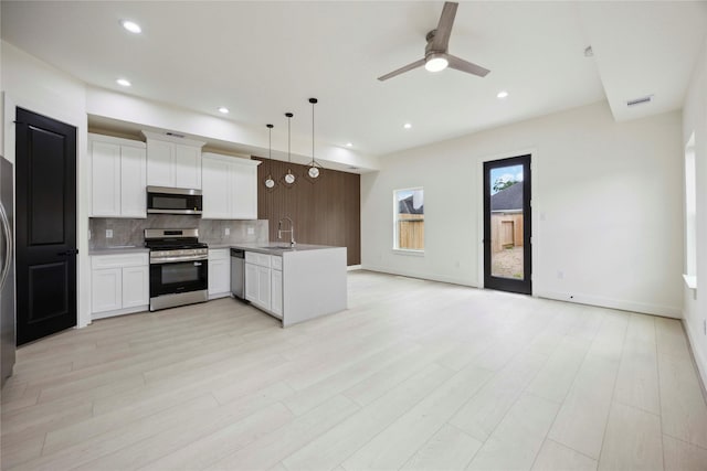 7906 Brandon St, Houston, TX 77051 - kitchen featuring stainless steel appliances, open floor plan, backsplash, a peninsula, and a ceiling fan