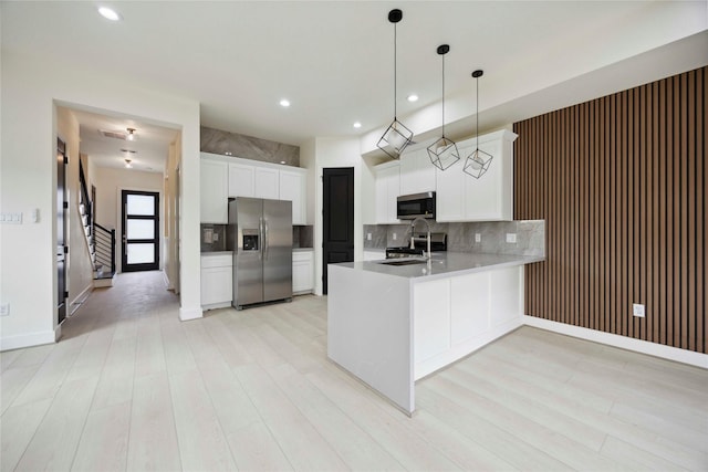 7906 Brandon St, Houston, TX 77051 - kitchen with appliances with stainless steel finishes, a peninsula, backsplash, light wood-style floors, and recessed lighting