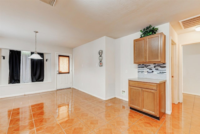14006 Marners Ct, Houston, TX 77014 - kitchen with light tile patterned flooring, tasteful backsplash, light countertops, and decorative light fixtures