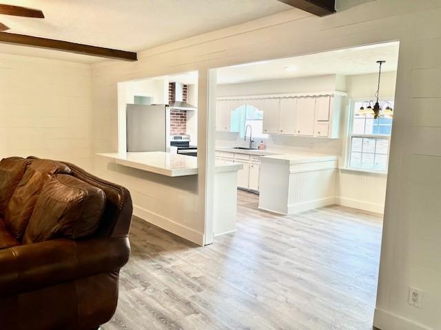 29019 Elmwood Dr, Shenandoah, TX 77381 - living area with light wood-type flooring, beam ceiling, and a chandelier
