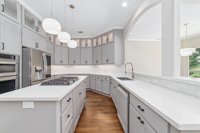 18 Sullivans Ct, Missouri City, TX 77459 - kitchen with stainless steel appliances, a kitchen island, ornamental molding, tasteful backsplash, and light countertops