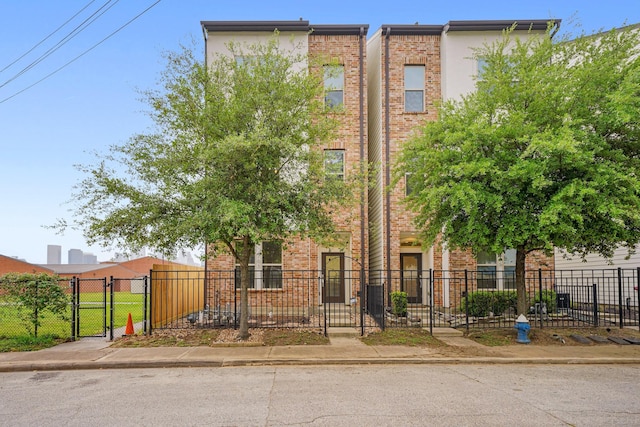 703 Schwartz St, Houston, TX 77020 - townhome / multi-family property with brick siding, a gate, and a fenced front yard