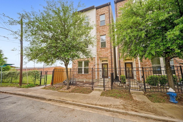 703 Schwartz St, Houston, TX 77020 - townhome / multi-family property featuring brick siding, a fenced front yard, and a gate