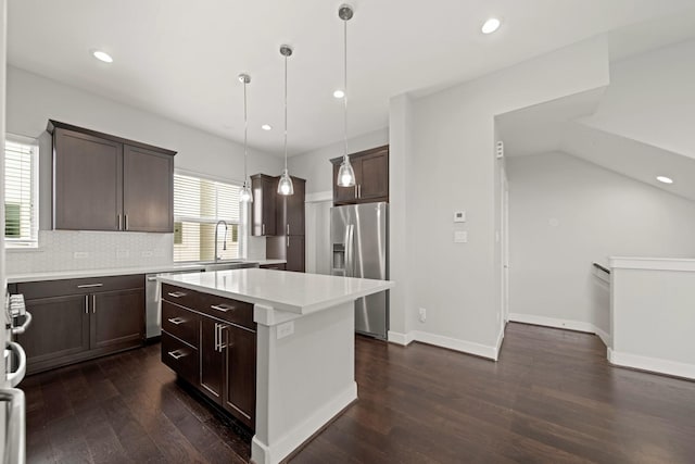 703 Schwartz St, Houston, TX 77020 - kitchen with appliances with stainless steel finishes, dark brown cabinets, dark wood-type flooring, a center island, and light countertops