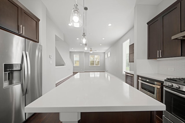703 Schwartz St, Houston, TX 77020 - kitchen featuring appliances with stainless steel finishes, beverage cooler, dark brown cabinets, light countertops, and recessed lighting
