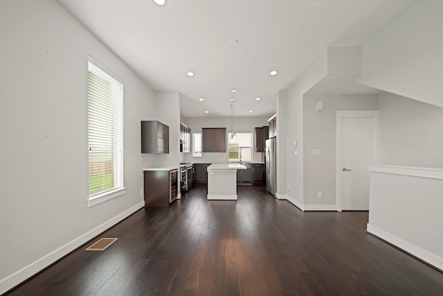 703 Schwartz St, Houston, TX 77020 - kitchen featuring freestanding refrigerator, a center island, light countertops, dark wood-style floors, and recessed lighting