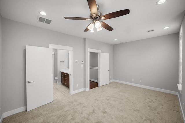 703 Schwartz St, Houston, TX 77020 - unfurnished bedroom featuring light colored carpet, recessed lighting, a spacious closet, ensuite bath, and a ceiling fan