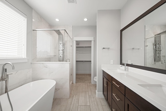 703 Schwartz St, Houston, TX 77020 - bathroom with a shower stall, double vanity, a soaking tub, a spacious closet, and recessed lighting