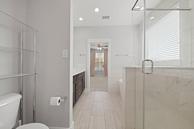 703 Schwartz St, Houston, TX 77020 - bathroom featuring vanity, a soaking tub, a stall shower, ceiling fan, and recessed lighting
