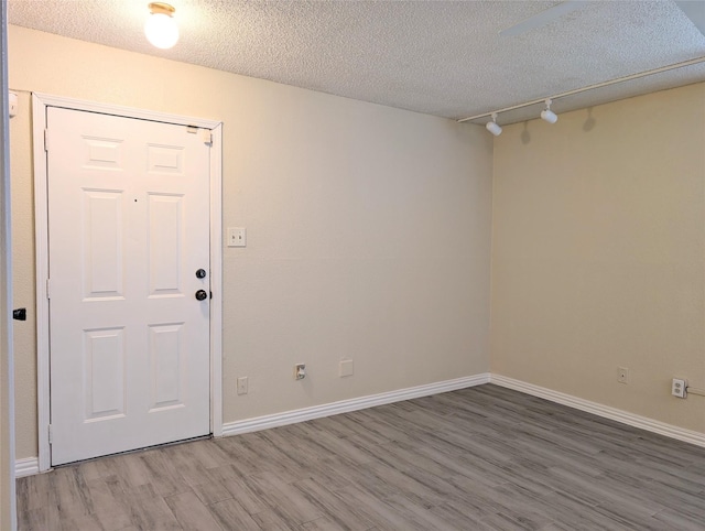 2750 Holly Hall St Unit 1504, Houston, TX 77054 - spare room with light wood-style flooring, a textured ceiling, and rail lighting