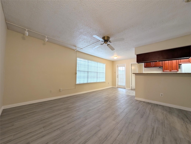 2750 Holly Hall St Unit 1504, Houston, TX 77054 - unfurnished living room with a textured ceiling, wood finished floors, a ceiling fan, and rail lighting