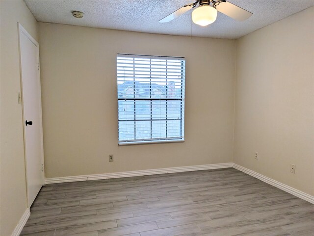 2750 Holly Hall St Unit 1504, Houston, TX 77054 - unfurnished room featuring a smoke detector, light wood-style flooring, ceiling fan, and a textured ceiling