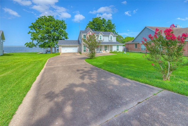 440 Lakeview Drive Loop, Coldspring, TX 77331 - traditional-style home with driveway, a front lawn, an attached garage, and a water view