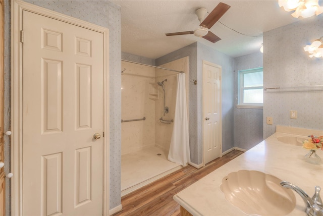 440 Lakeview Drive Loop, Coldspring, TX 77331 - bathroom featuring wood finished floors, wallpapered walls, a stall shower, double vanity, and a ceiling fan