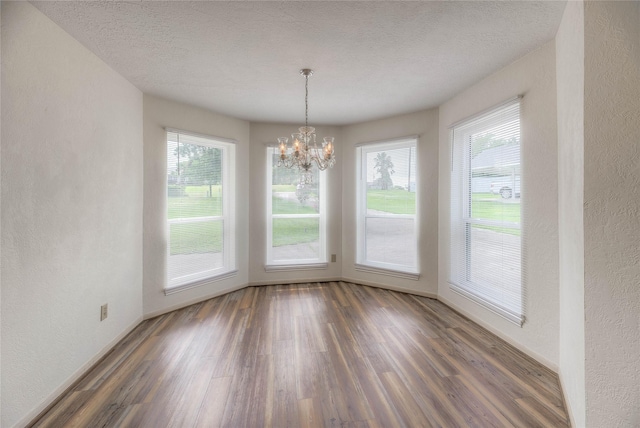440 Lakeview Drive Loop, Coldspring, TX 77331 - unfurnished dining area with a textured wall, wood finished floors, a chandelier, and a textured ceiling