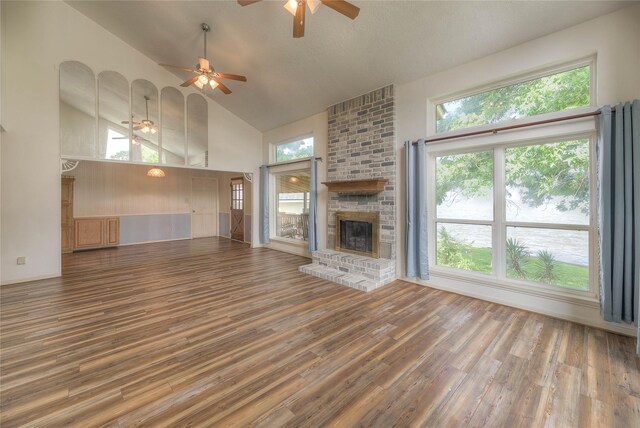 440 Lakeview Drive Loop, Coldspring, TX 77331 - unfurnished living room with ceiling fan, high vaulted ceiling, wood finished floors, and a brick fireplace