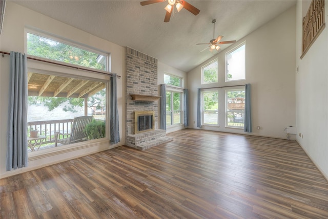 440 Lakeview Drive Loop, Coldspring, TX 77331 - unfurnished living room with a ceiling fan, wood finished floors, a fireplace, plenty of natural light, and high vaulted ceiling